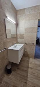 a bathroom with a white sink and a mirror at Lodge Ti Bonheur in Sainte-Anne