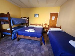 two beds in a room with blue sheets at Hotel America in Victoria