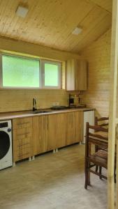 a kitchen with wooden cabinets and a sink and a stove at Guest House Adelina in Mestia