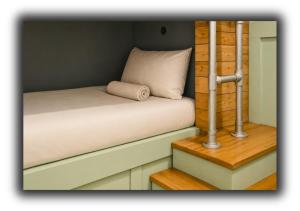 a small bed with a pillow on it in a room at Pitchside Rooms in Liverpool