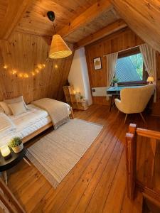 a bedroom with a bed and a desk in a room at Wiśniowa Chata in Rentyny