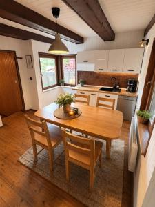 a kitchen with a wooden table and chairs in it at Wiśniowa Chata in Rentyny