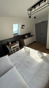 a large white bed in a room with a table at Dom przy Wangu Karpacz in Karpacz