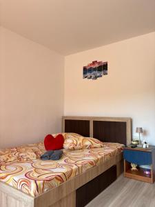 a bedroom with a bed with a red pillow on it at Casa Iulia in Eşelniţa