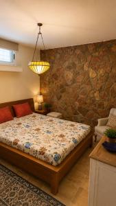a bedroom with a bed and a stone wall at Villa Bleu Horizon in El Haouach +16 photos