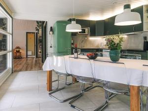 a kitchen with green cabinets and a table with chairs at 4 star holiday home in Væggerløse in Bøtø By