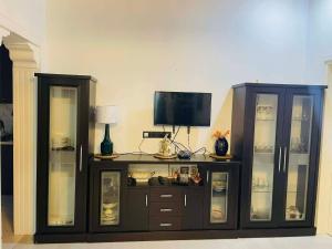 a entertainment center with glass doors and a television on top at Appartaments Anna Kostava in Kobuleti