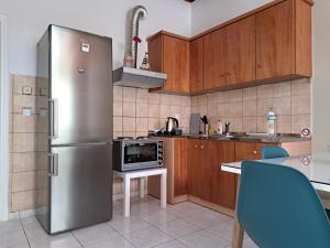 a kitchen with a refrigerator and a table with chairs at Stone Family Home Garden Center Beach in Kyparissia +10 photos