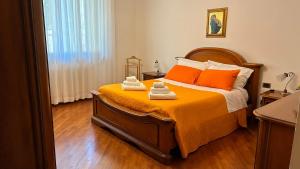 a bedroom with a bed with orange sheets and orange pillows at Tuscan Charm Spacious Florence Home in Campi Bisenzio