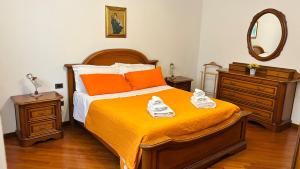a bedroom with a bed with orange sheets and shoes on it at Tuscan Charm Spacious Florence Home in Campi Bisenzio