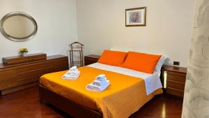 a bedroom with a bed with orange pillows and a mirror at Tuscan Charm Spacious Florence Home in Campi Bisenzio
