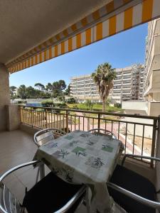 a table and chairs on a balcony with a view of a building at Cozy Apartment with Pool at 5 Min to Beach in Salou