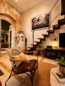 a living room with a staircase and a chair at Narkis - A Boutique Stay in the Heart of Jerusalem in Jerusalem
