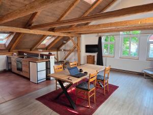 a kitchen with a wooden table with a laptop on it at Apartmán U lípy in Semily