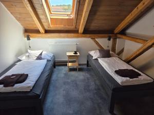 two beds in a small room with a window at Apartmán U lípy in Semily