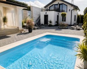 a swimming pool in front of a house at Pensiunea Coralia in Deva