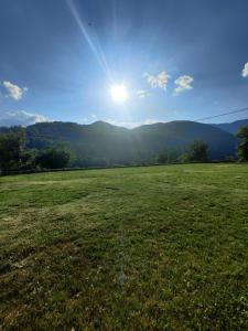 a field of grass with the sun in the sky at Guest House Trojani in Lëpushë