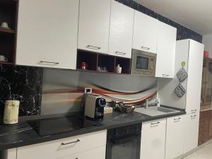 a kitchen with white cabinets and a microwave at Casa Maya Langhe e Roero in Pocapaglia