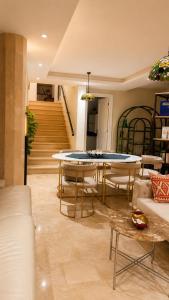 a living room with a table and chairs and stairs at Villa Bleu Horizon in El Haouach