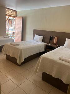 a hotel room with two beds and a window at Hotel El Huacachinero- Hotel Familiar in Ica +43 photos