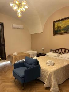 une chambre avec deux lits et une chaise bleue dans l'établissement Sicily home, à Ribera