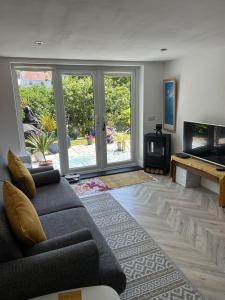 a living room with a couch and a flat screen tv at East Barn Garden View in Georgeham