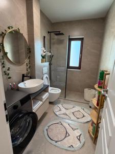 a bathroom with a sink and a toilet and a shower at L&D Apartments in Urseni +27 photos