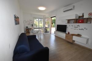 a living room with a blue couch and a tv at Casa Lorica in Pieve Ligure