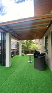 a patio with green grass and a table and chairs at Casa Domingo Guest House in Camalig