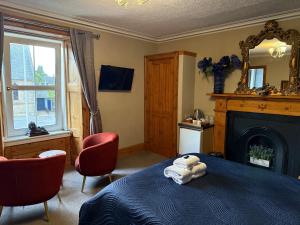 a bedroom with a bed with a teddy bear on it at Dionard Guest House in Inverness