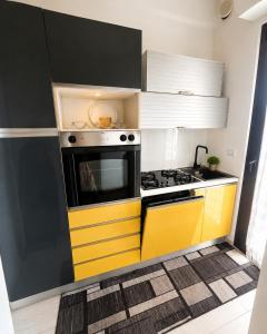a kitchen with a yellow and black stove and cabinets at Piazza Sant'Alfonso Apartment in Francavilla al Mare