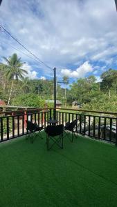 two chairs and a grill on a balcony with green grass at Casa Domingo Guest House in Camalig
