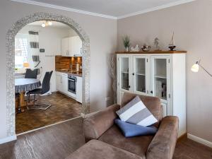 a living room with a couch and a kitchen at Ferienwohnung *Jessen´s Wattblick* in Wittdün
