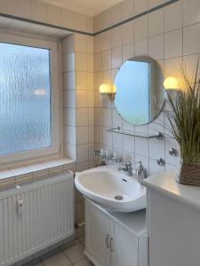 a bathroom with a sink and a mirror at Ferienwohnung *Jessen´s Wattblick* in Wittdün +37 photos