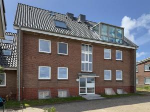 a brick building with a balcony on top of it at Ferienwohnung *Jessen´s Wattblick* in Wittdün