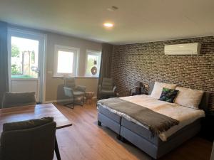 ein Schlafzimmer mit einer Backsteinwand und einem großen Bett in der Unterkunft De Brummelstee in Beilen + 4 Fotos