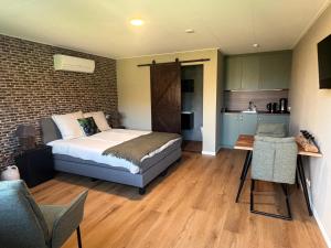ein Schlafzimmer mit einem Bett und einer Küche darin in der Unterkunft De Brummelstee in Beilen