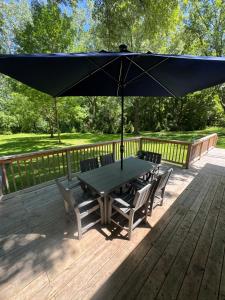 a table with chairs and an umbrella on a deck at The Borderland in Michigan City
