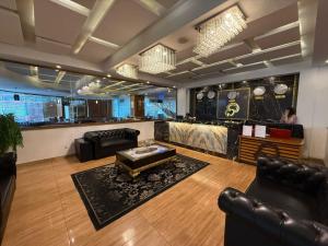 a lobby with leather furniture and a bar in the background at Grand Mongolia in Rawalpindi