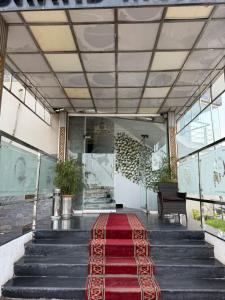 a hallway with a red rug on the stairs at Grand Mongolia in Rawalpindi