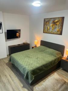 a bedroom with a bed and a flat screen tv at 2 минуты до моря in Batumi