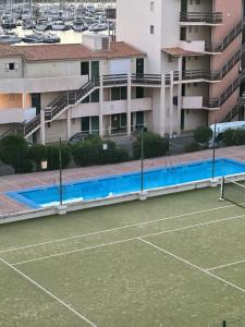 a tennis court in front of a building at Appt Cap d'Agde in Agde