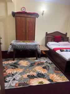 a bedroom with two beds and a rug on the floor at Kattel HomeStay And Apartments in Bālāju