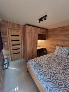 a bedroom with a bed and a wooden wall at MAZI HOUSE Jastarnia in Jastarnia
