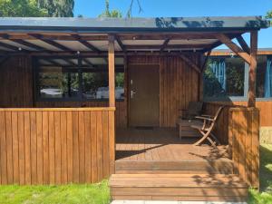 a wooden pergola with a bench on a deck at MAZI HOUSE Jastarnia in Jastarnia