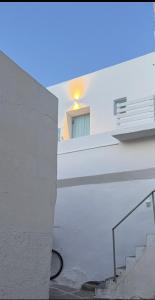 a white building with a staircase and a window at Eugene Sea Side Suite in Naousa