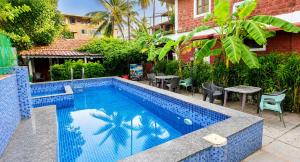 a blue tile swimming pool with a table and chairs at Hotel Casa viora at swimming pool in Calangute