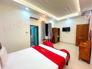 a bedroom with a red and white bed and a tv at Hotel PHƯƠNG MAI 2 in Bến Lức