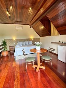 a bedroom with a bed and a table and chairs at Hotel Gran Minas in Vespasiano