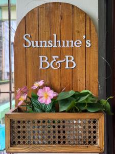 a wooden sign with flowers in a box at Sunshine Stays in Siliguri